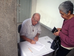 2012: Leopoldo na entrada do Santuário, em suas atividades dominicais. Veja dois detalhes: O sempre presente tau franciscano, no peito e o santinho de divulgação do amigo Frei Cosme sobre a mesa.